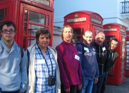 Personnes accompagnées des Cigalons devant des cabines téléphoniques londoniennes